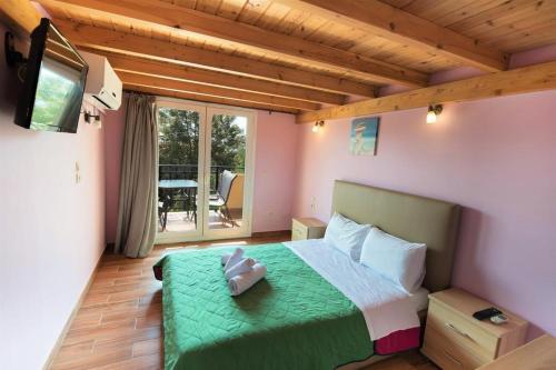 瓦西利基阿尔戈公寓酒店的一间卧室配有一张带绿毯的床和一台电视