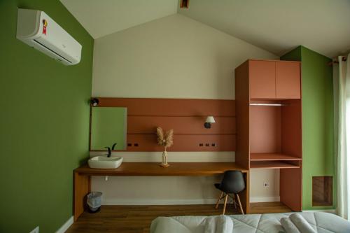 JaguariaívaChakras Pousada的一间卧室设有绿色和白色的墙壁和书桌