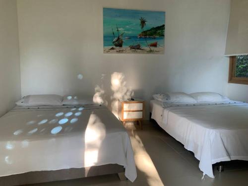 普拉多Casa Paraiso del Lago的一间卧室设有两张床,墙上挂着一幅画