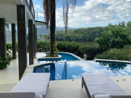 普拉多Casa Paraiso del Lago的河景房屋 - 带游泳池