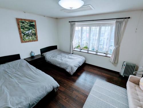 柳川柳川ゲストハウス 憩 (IKOI)的一间卧室设有两张床和窗户。