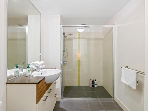 布里斯班City Centre 3BR Apartment with Stunning Views的带淋浴和盥洗盆的白色浴室