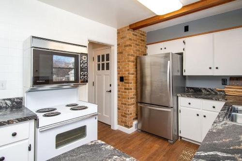 法戈NEW Charming Home in the Heart of North Fargo的厨房配有白色橱柜和不锈钢冰箱