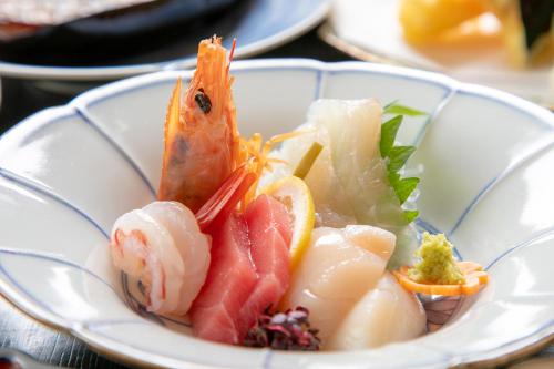 佐贺市Tsukasa Ryokan的桌上一盘带海鲜的食品