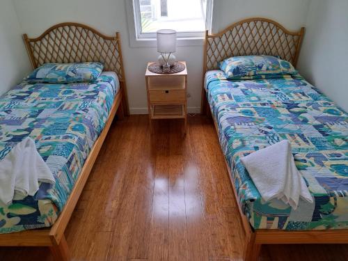 天阁露玛莫顿岛别墅及公寓酒店的卧室设有两张单人床、床头柜和台灯。