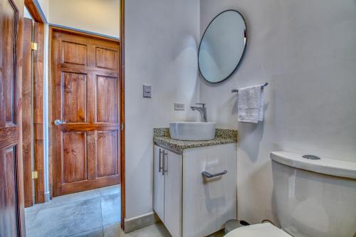 塔马林多Muna Tamarindo的一间带水槽、卫生间和镜子的浴室