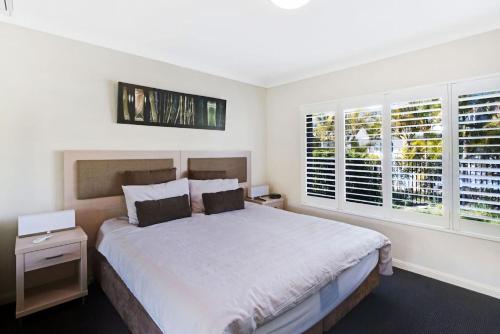萨拉曼德湾Oaks Pacific Blue Pool spa more in complex的卧室设有白色大床和窗户。