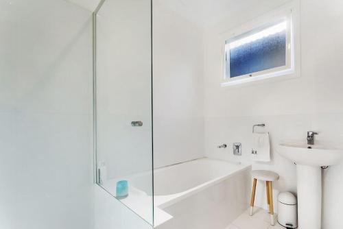 尼尔森湾Luxury on Dutchmans Beach的带淋浴和盥洗盆的白色浴室