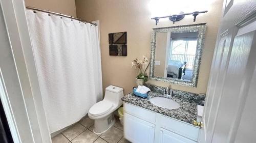 基西米Beautiful 3 Bedroom Apartment minutes from Disney!的一间带卫生间、水槽和镜子的浴室