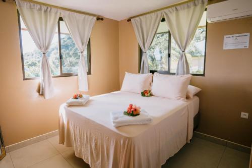 波拉波拉Vue imprenable sur le lagon de Bora Bora的卧室配有一张白色大床和两个窗户