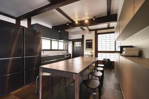 海津市奥琵琶湖　四季亭的厨房配有木桌和一些椅子