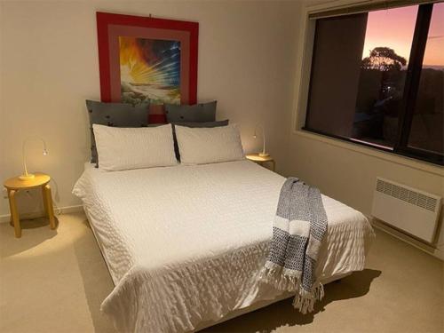 墨尔本Superb City Views - Apartment, work or just relax!的卧室设有一张白色大床和一扇窗户。