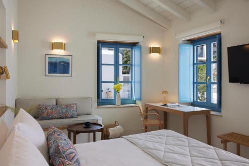 伊兹拉Orloff Legacy Suites Hydra的卧室配有床、桌子和窗户。