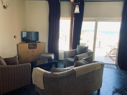 赫尔格达赫尔格达景观别墅公寓酒店的客厅配有两张沙发和一台电视
