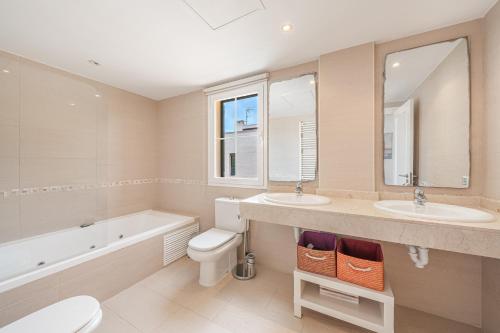 柳奇马约尔Villa Alma Azul的一间带两个盥洗盆、浴缸和卫生间的浴室