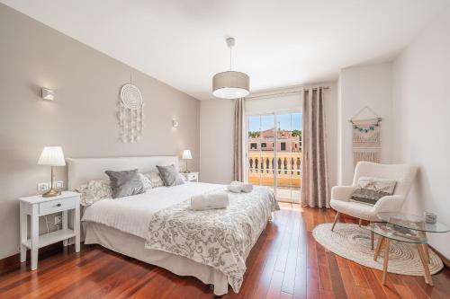柳奇马约尔Villa Alma Azul的白色卧室设有床、椅子和窗户
