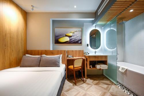 胡志明市La Opera Saigon Hotel的一间卧室配有一张床,浴室设有浴缸