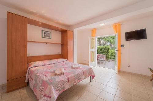 卡波利韦里Villino nel Bosco的一间卧室配有一张床、一台电视和一个庭院。