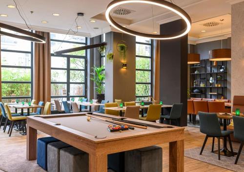 布鲁塞尔Holiday Inn Brussels Schuman, an IHG Hotel的配有桌椅的房间的台球桌