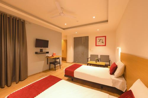 新德里The Grand Tashree at Delhi Airport的酒店客房设有两张床和电视。