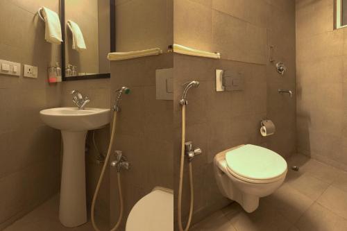 新德里The Grand Tashree at Delhi Airport的浴室配有卫生间、盥洗盆和淋浴。