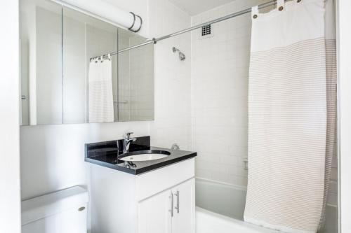 纽约Murray Hill 1BR w Doorman Gym Pool Parking NYC-581的白色的浴室设有水槽和淋浴。