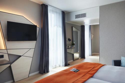 杜塞尔多夫the niu Hub的配有一张床和一台平面电视的酒店客房