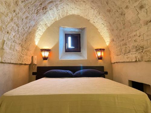 奥斯图尼Casa Vega的卧室配有一张石墙床