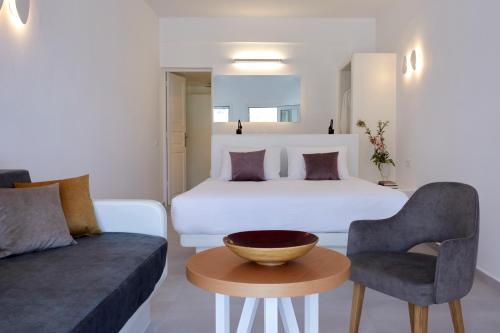 伊亚安科尔套房公寓的一间卧室配有一张床、一张沙发和一张桌子