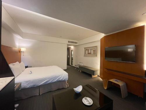 台中市永丰栈酒店的配有一张床和一台平面电视的酒店客房