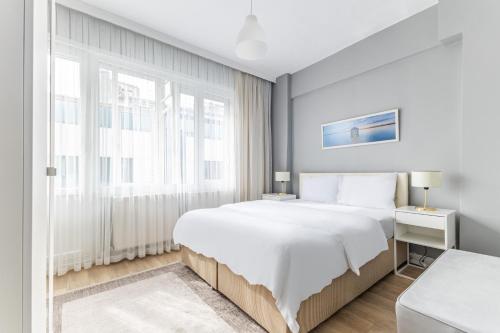 伊斯坦布尔Modern Stylish Cozy Flat in the Heart of Kadikoy的白色的卧室设有一张大床和一个窗户