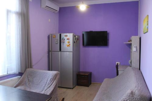 第比利斯Sweet home的紫色客房配有冰箱和电视