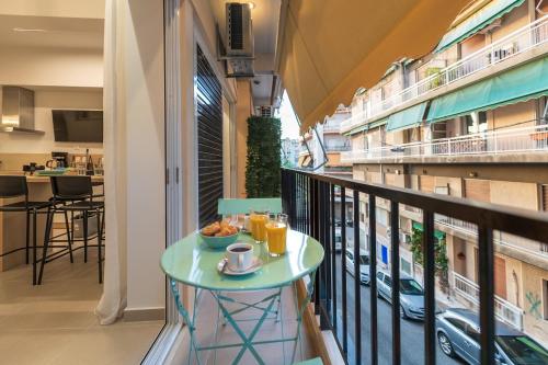 雅典Feel like home的阳台配有桌子,早餐在阳台上供应。