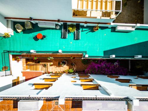 马贝拉Marbella Village的一张长桌子,上面有黄色的椅子和绿色的墙壁