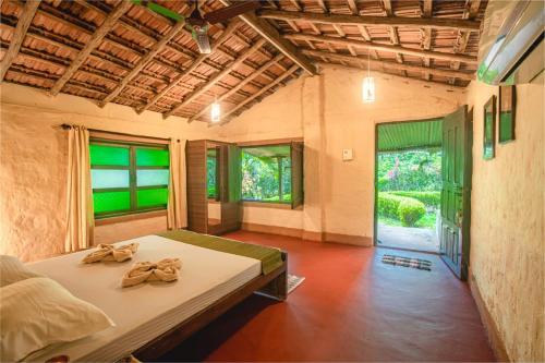 MolemNature's Nest Eco Resort Goa, Near Dudhsagar Waterfalls的一间卧室配有带毛巾的床