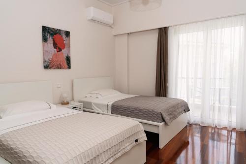 雅典Visum Acropol ,3BR - Private Terrace-Jacuzzi - Amazing View的一间卧室设有两张床和窗户。