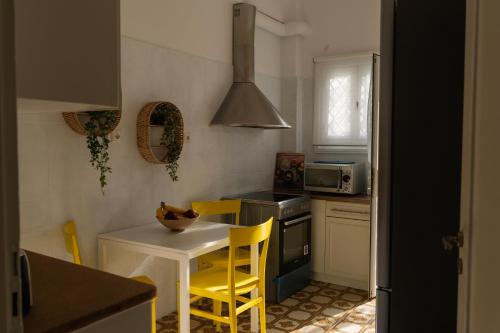 雅典Visum Acropol ,3BR - Private Terrace-Jacuzzi - Amazing View的厨房配有白色的桌子和黄色的椅子