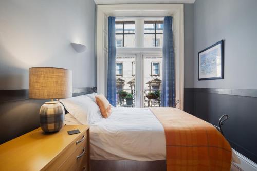 格拉斯哥西乔治街公寓酒店的一间卧室配有一张带书桌的床和窗户。