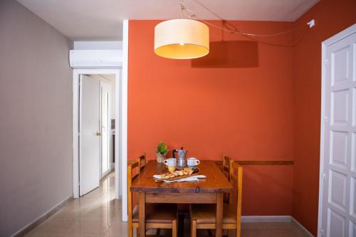 埃斯塔蒂特热带公寓RV酒店的一间拥有橙色墙壁和木桌的用餐室