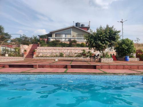 瓦伊Hilltop Resort and Agro Tourism Wai, Near Panchgani的房屋前有游泳池的房子