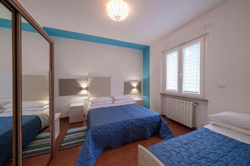 下麦克加诺Casa Vacanza Acqua Dolce的一间卧室配有两张床和镜子