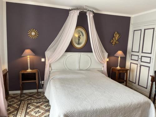 格里莫LA MAISON DE JUSTINE的一间卧室配有一张带天蓬的白色床