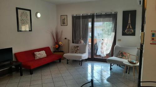 奥尔比亚PRESSI AEROPORTO COSTA SMERALDA的客厅配有红色的沙发和两把椅子