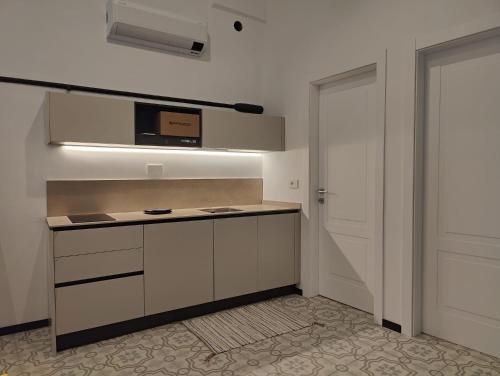 阿拉西奥Casa Aicardi的厨房配有白色橱柜和微波炉
