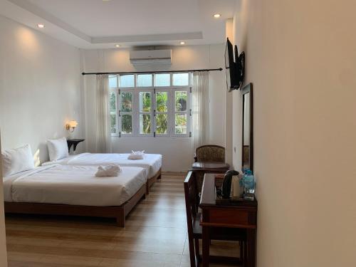 琅勃拉邦La nuit de laos的一间卧室设有一张大床和一个窗户。
