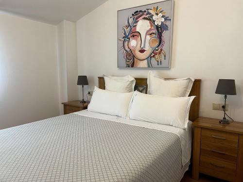 波伊奥卡萨奥姆诺旅馆的一间卧室配有一张带白色枕头的床和一幅画
