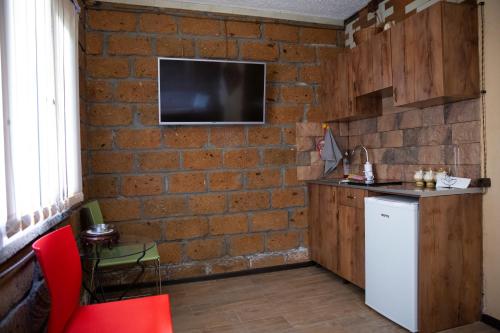 NamazaluNoravank L-and-L的厨房设有砖墙和白色冰箱。