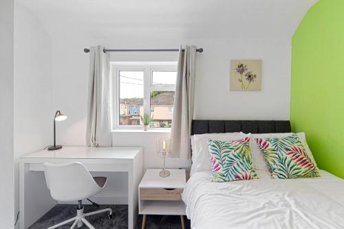 布里斯托Grayle House by Cliftonvalley Apartments的一间卧室配有一张床、一张桌子和一把椅子