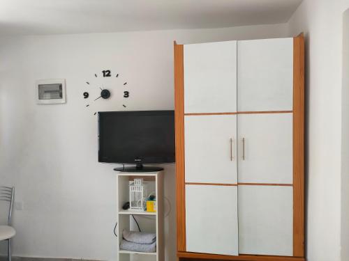 罗萨里奥港Casa Alba 2的一间带电视和白色橱柜的客厅