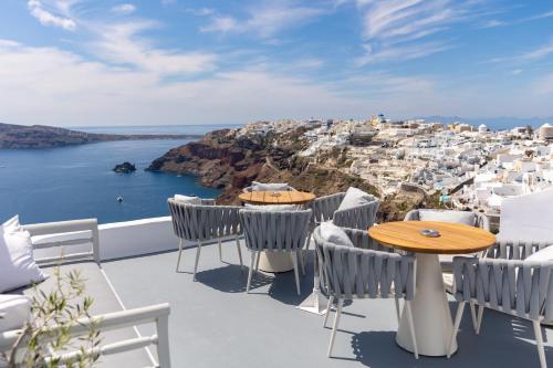伊亚IKIES Santorini的设有带桌椅的市景阳台。